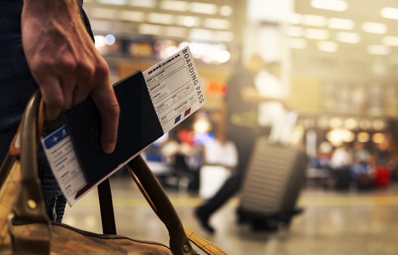Traveller holding a passport and boarding pass in an airport