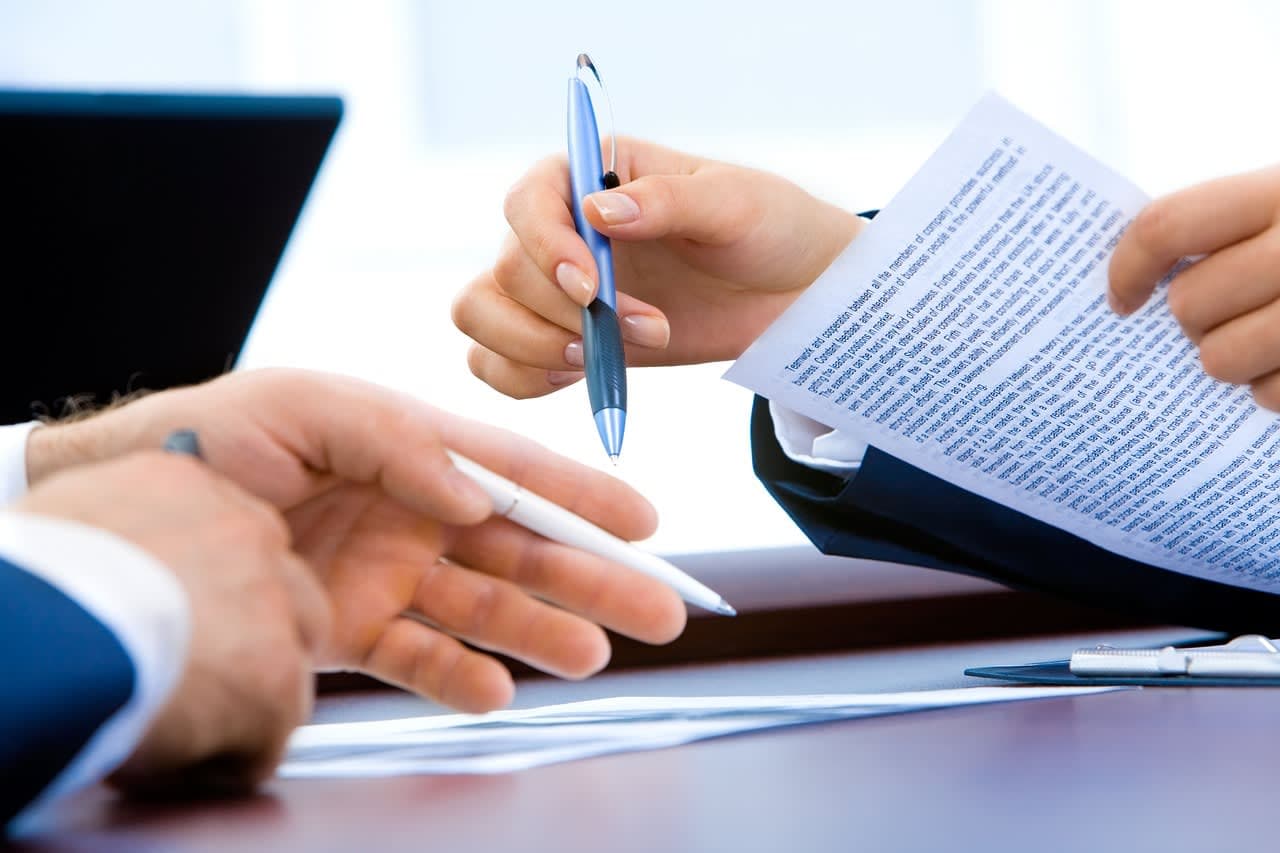Two professionals reviewing a contract at a desk