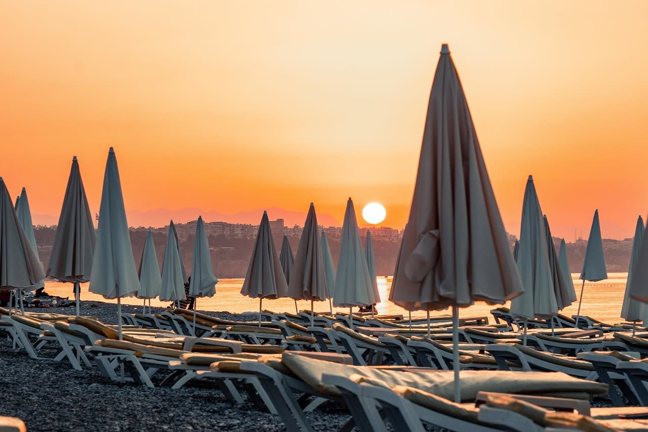 Sun loungers and closed parasols on an Antalya beach at sunrise